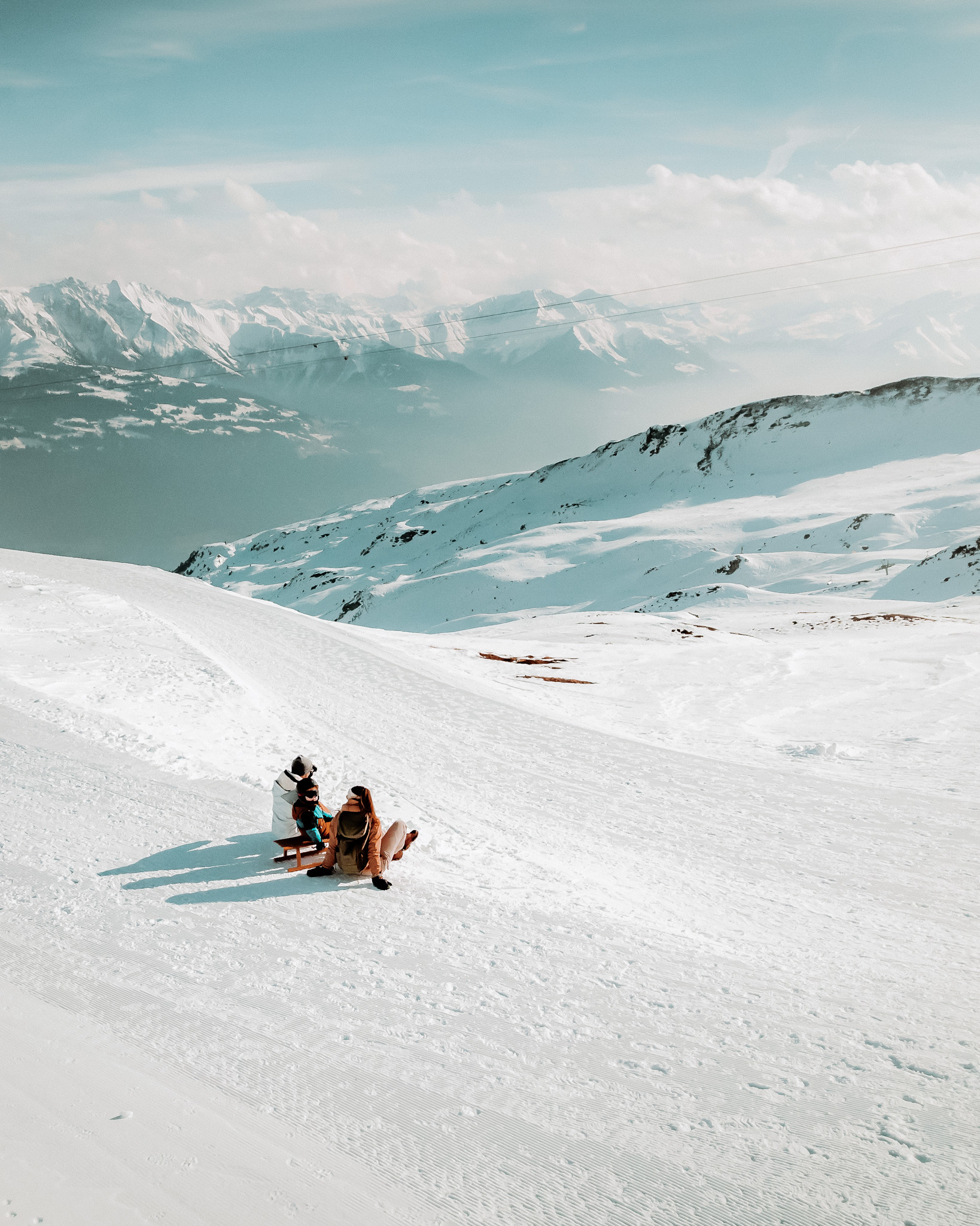 gezin is van het uitzicht aan het genieten tijdens een wandeling tussen de besneeuwde bergtoppen van flims laax zwitserland.