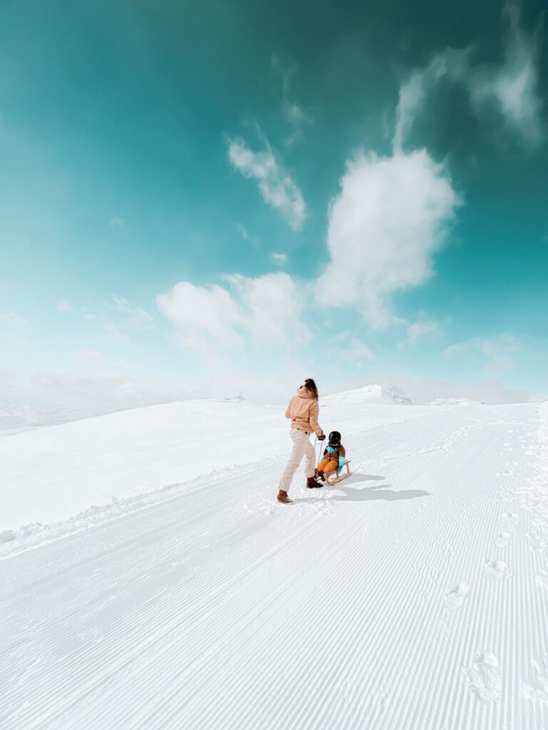 sleeën in de sneeuw moeder zoon door bergen in zwitserland
