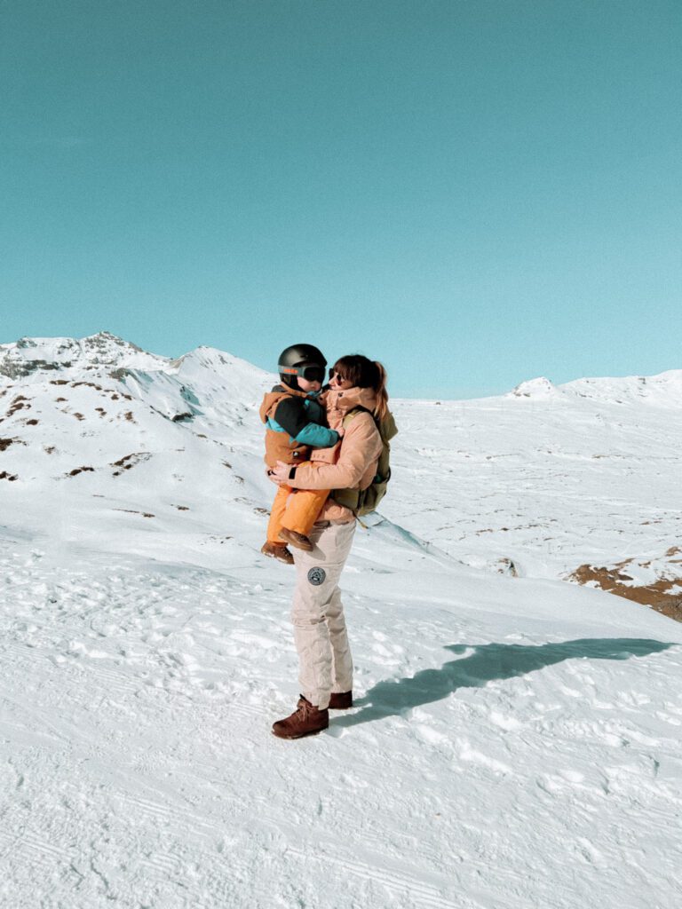moeder en zoon poseren in de sneeuw bergen tijdens wandeling van laax flims zwitserland
